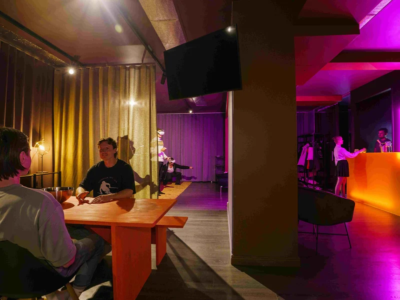 Juhlaporukka baarin ja pelipöydän äärellä GameSpacessa
